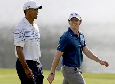 Tiger Woods and Rory McIlroy, of Northern Ireland, walk up the fairway of the 17th hole.
