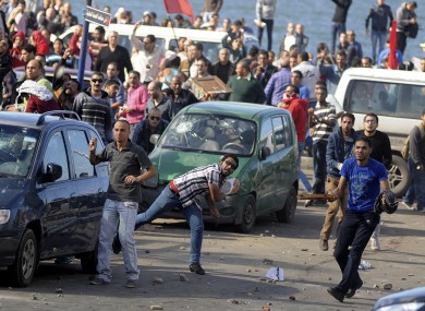 Protesters hurl stones during clashes between supporters and opponents of President Mohammed Morsi in Alexandria, Egypt,