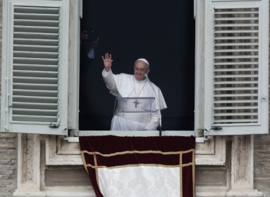 Pope Francis waves to the crowd in St Peter's Square after saying the Angelus this morning