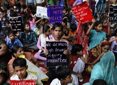 Indian children hold placards as they participate in a protest over the deaths.