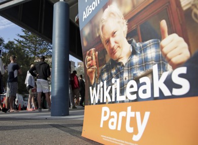 A placard showing WikiLeaks founder Julian Assange is set up as voters line up to fill in their ballots at a polling booth at Bondi Beach in Sydney.