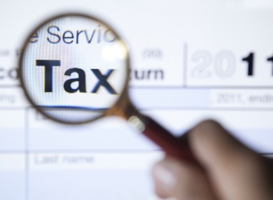 Magnifying glass over the word tax on a form